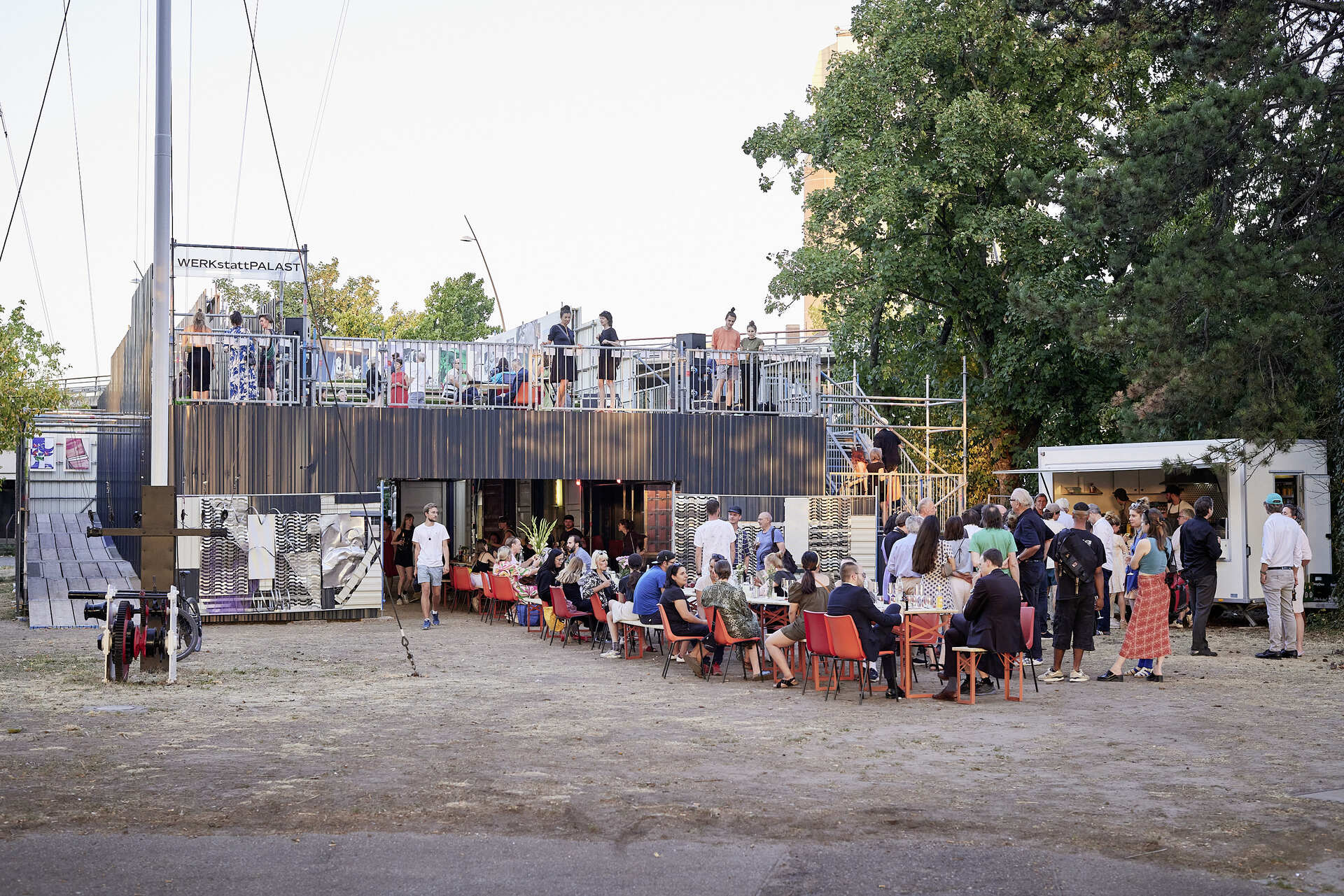 Außenansicht des WERKstattPALAST mit Crowd an langen Tischen